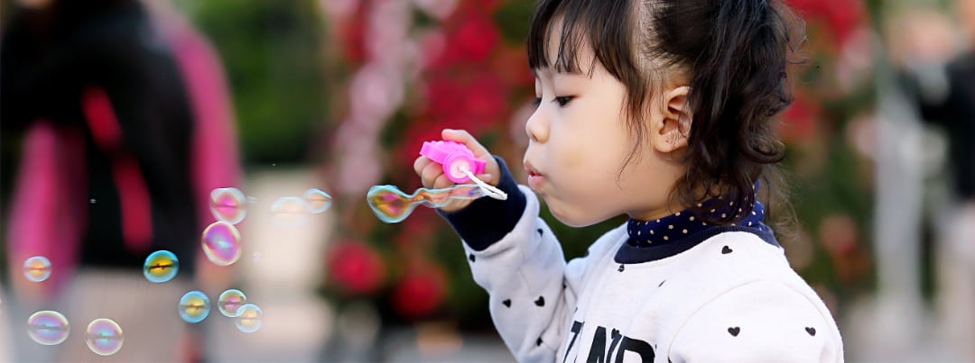 young girl blowing bubbles